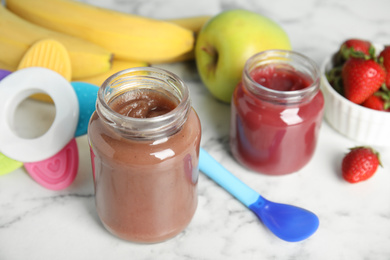 Photo of Healthy baby food in jars and fresh ingredients on white marble table