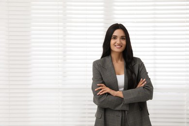 Photo of Beautiful woman in formal suit near window, space for text. Business attire