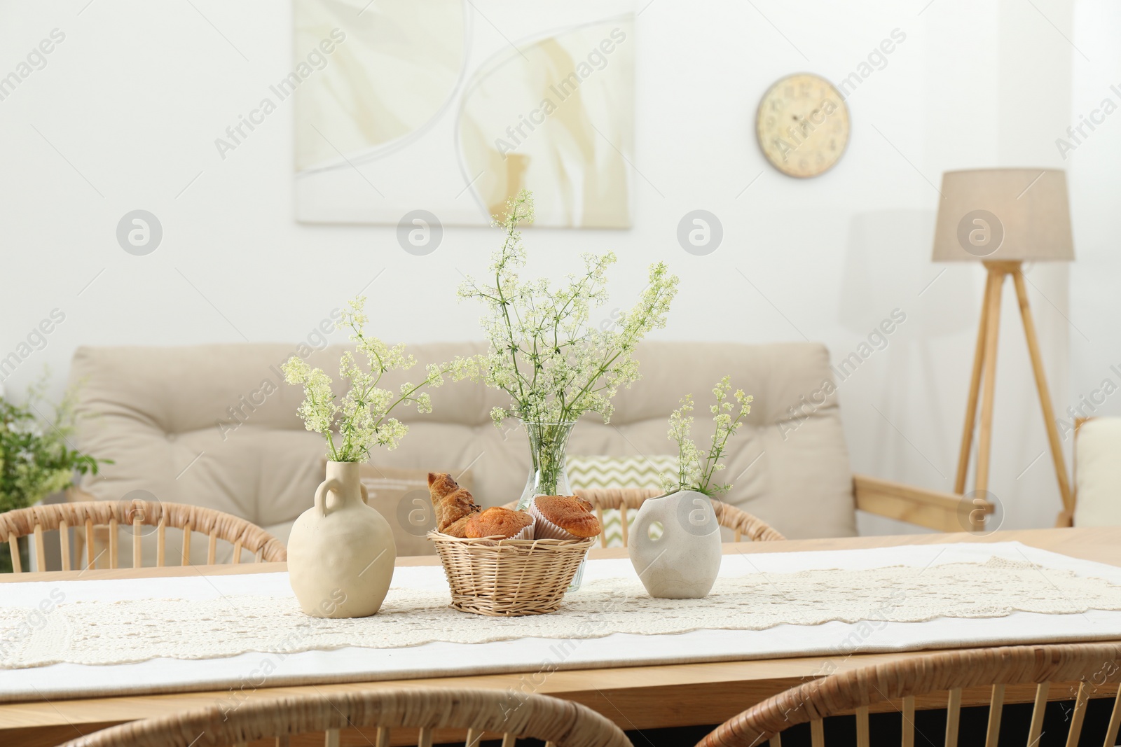 Photo of Fresh pastries and beautiful flowers on table in stylish dining room