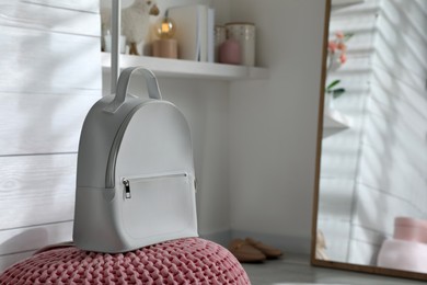 Photo of Stylish backpack on pouf in dressing room