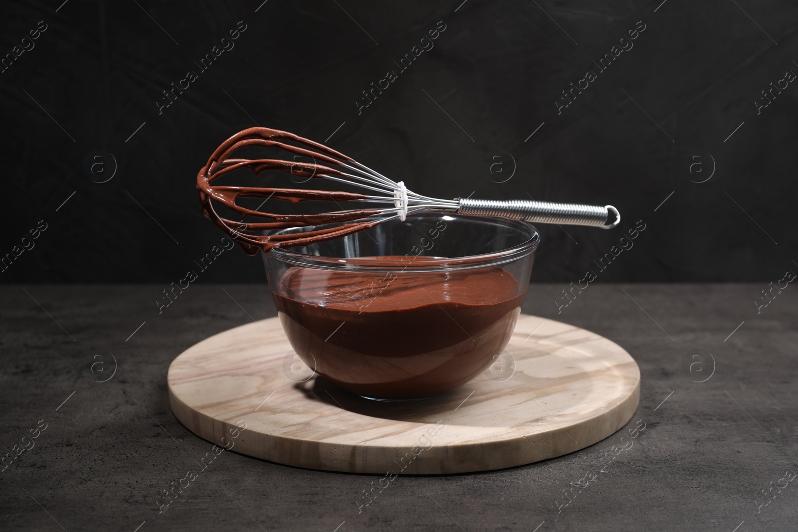 Photo of Bowl of chocolate cream and whisk on gray table