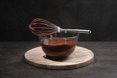 Photo of Bowl of chocolate cream and whisk on gray table