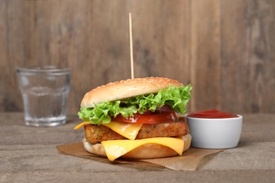 Delicious tofu burger served with sauce on wooden table