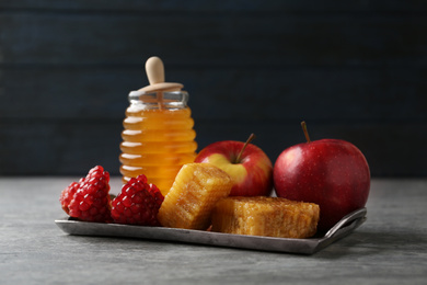 Photo of Honey, apples and pomegranate on grey table. Rosh Hashanah holiday