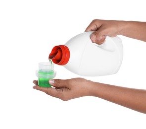 Woman pouring fabric softener from bottle into cap on white background, closeup