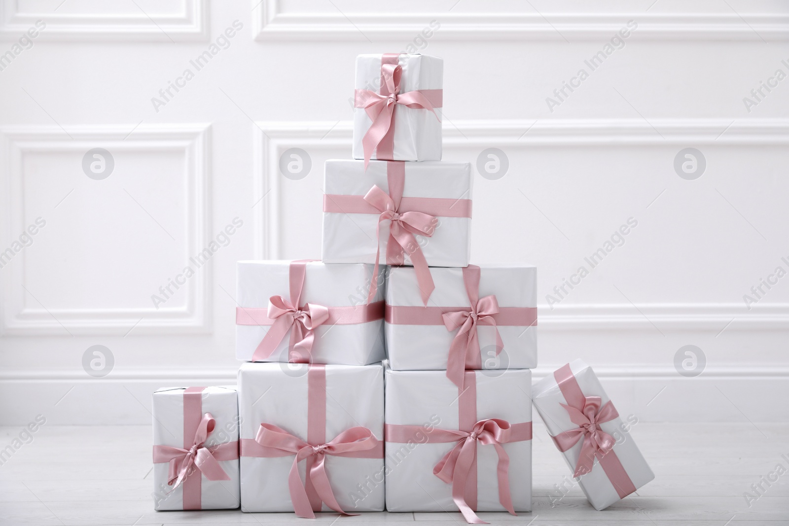 Photo of Many gift boxes on floor near white wall in room