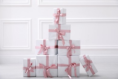 Photo of Many gift boxes on floor near white wall in room