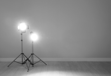 Photo of Professional lighting equipment near wall in photo studio. Space for text