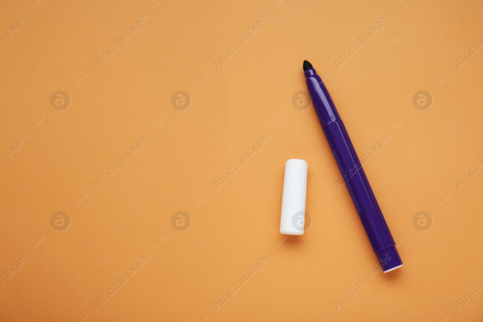 Photo of Purple marker on light brown background, flat lay. Space for text