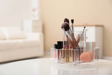 Organizer with makeup cosmetic products on table indoors. Space for text