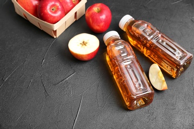 Bottles of apple juice on grey background