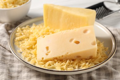 Photo of Grated and whole pieces of cheese on table, closeup