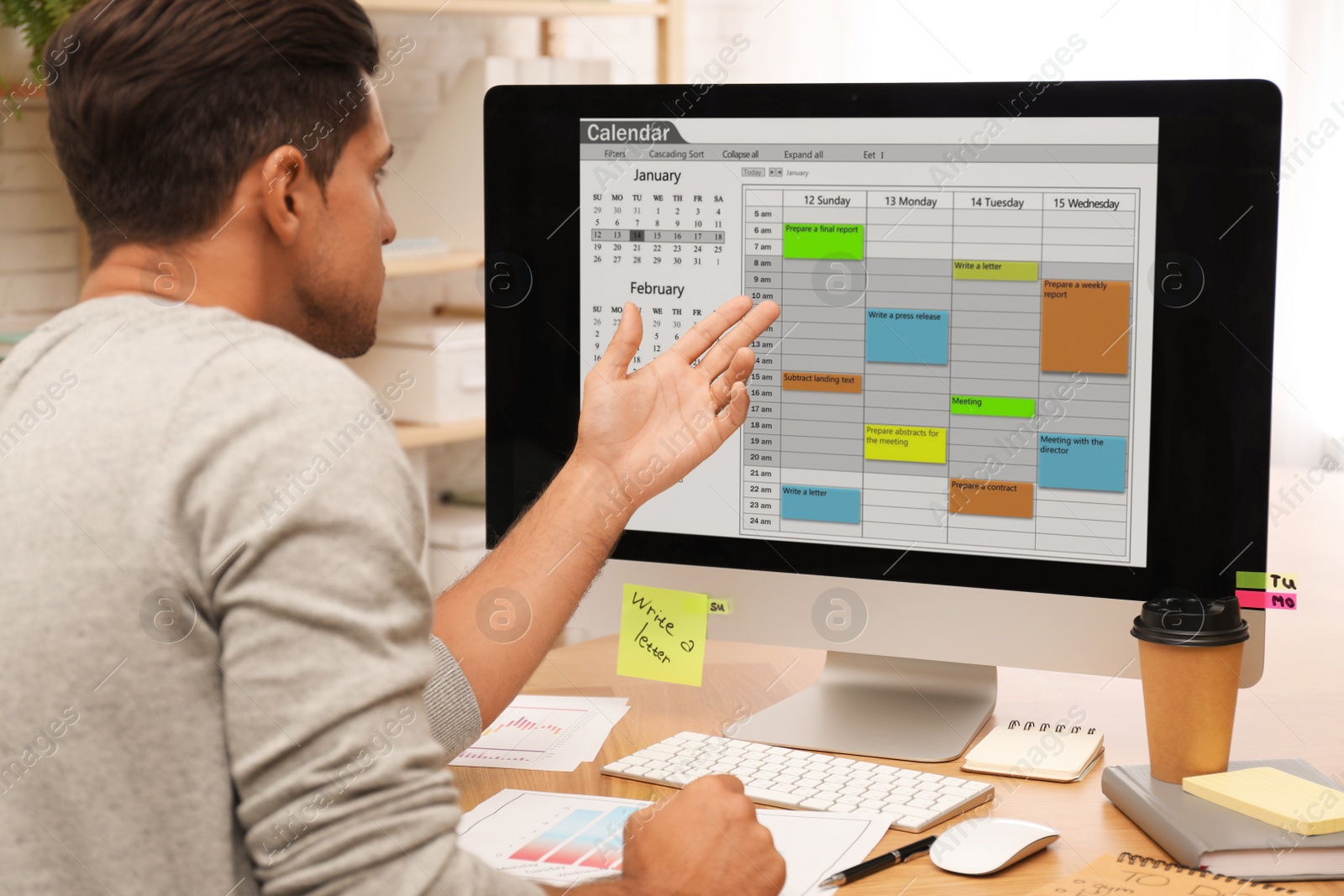 Photo of Handsome man using calendar app on computer in office