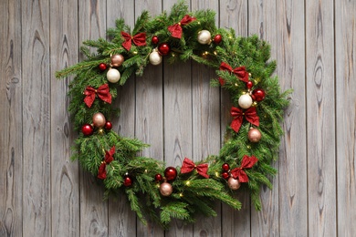 Photo of Beautiful Christmas wreath with festive decor on wooden background, top view