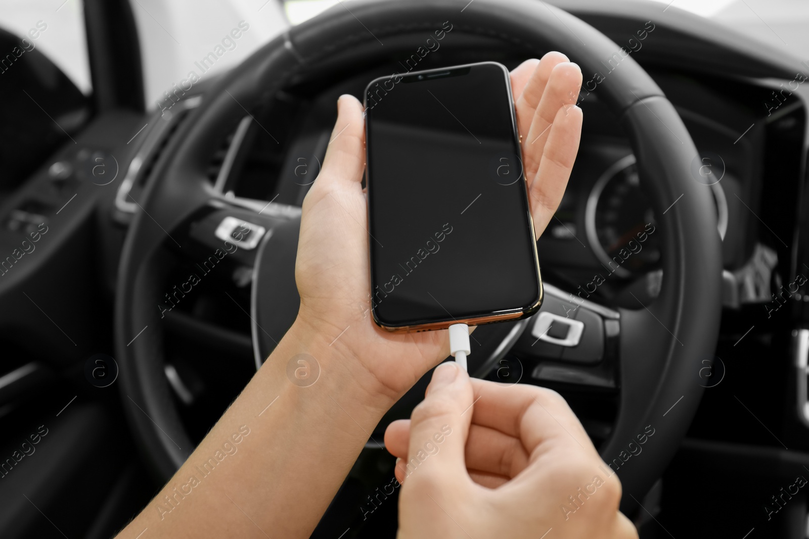 Photo of Person charging phone with USB cable in car