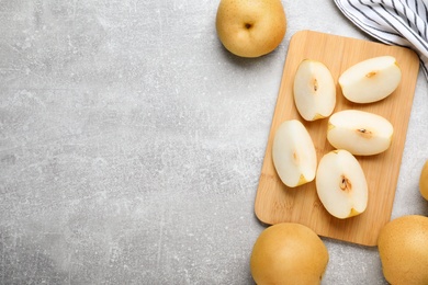 Photo of Cut and whole apple pears on grey table, flat lay. Space for text