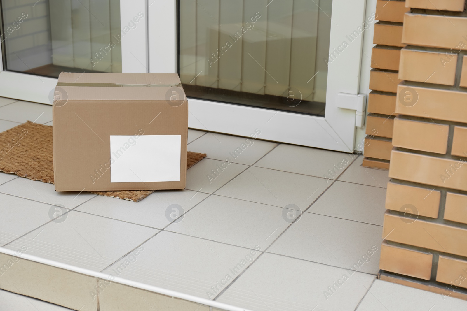 Photo of Delivered parcel on door mat near entrance