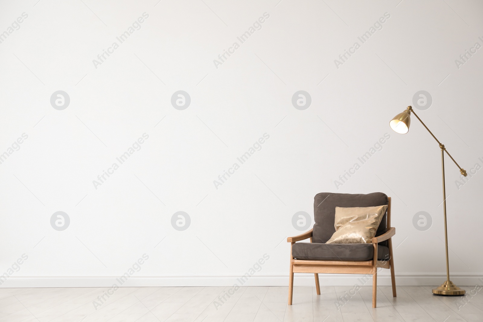 Photo of Stylish living room interior with wooden armchair and floor lamp near white wall. Space for text