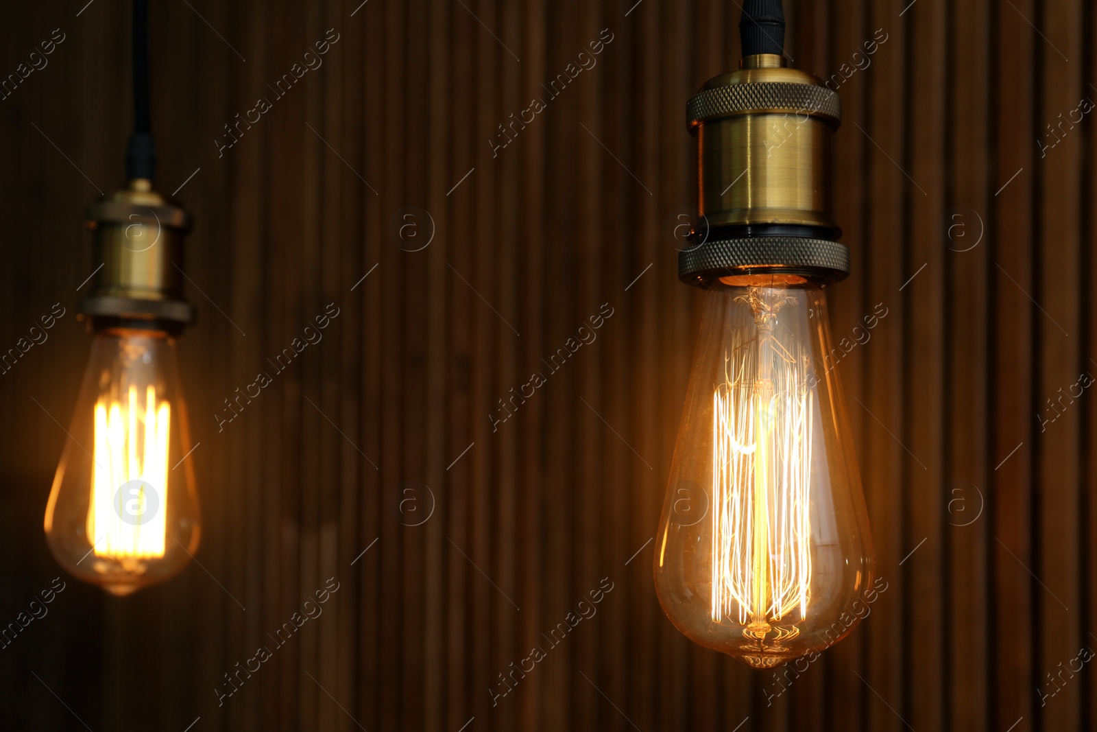 Photo of Pendant lamps with light bulbs on wooden background