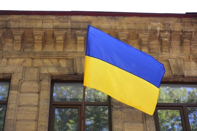 Photo of National flag of Ukraine on old building wall outdoors