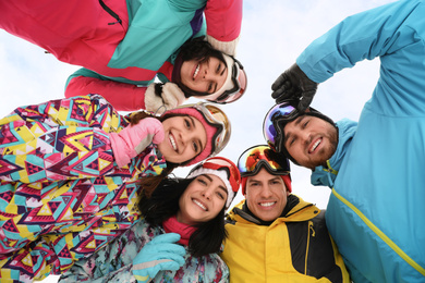 Photo of Group of friends joined in circle outdoors, bottom view