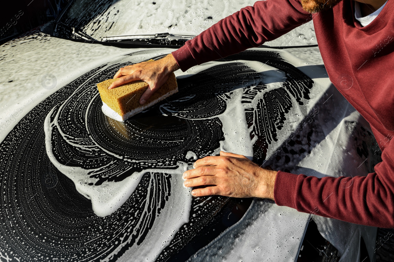 Photo of Worker washing auto with sponge, closeup view