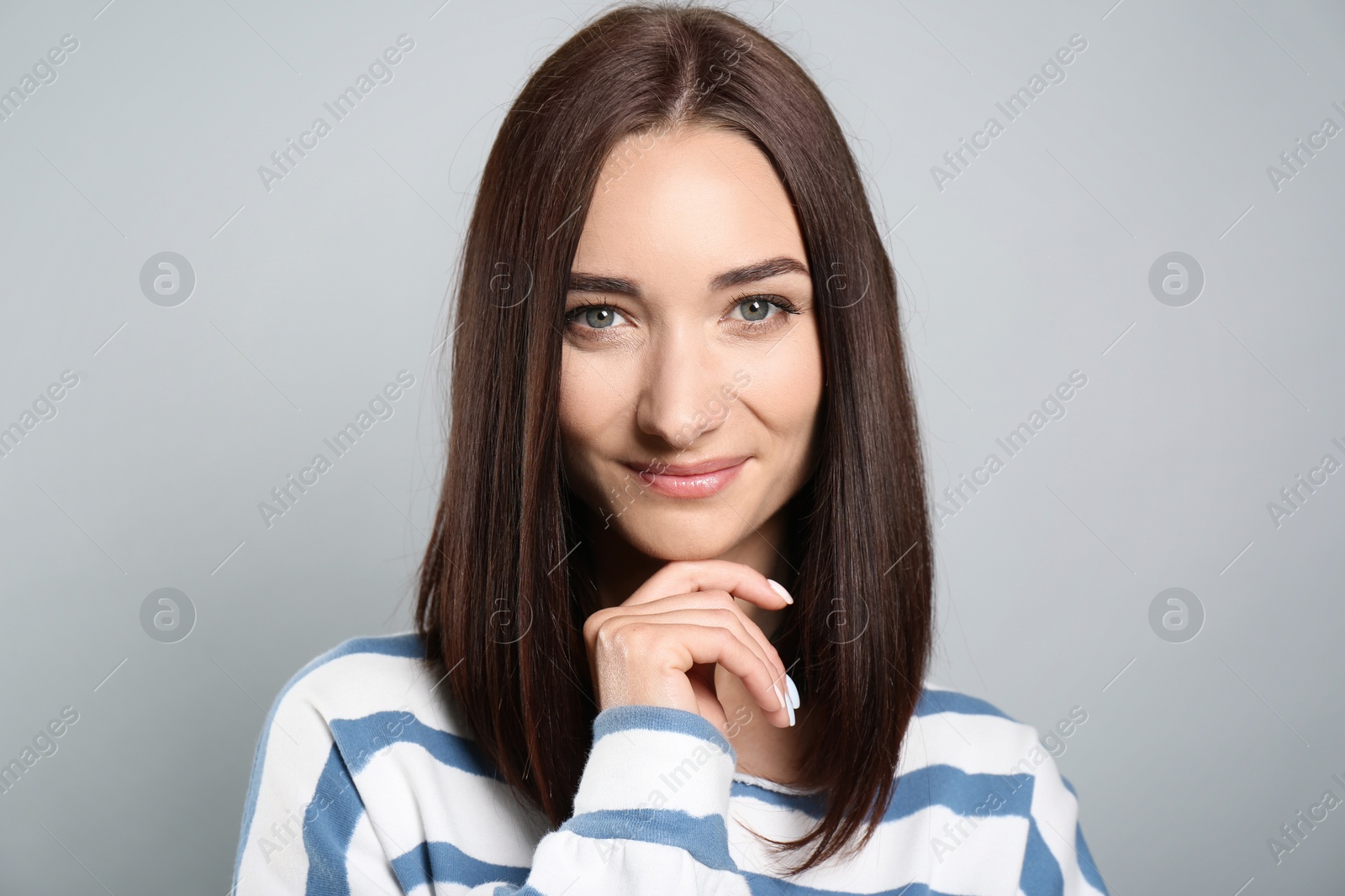 Photo of Portrait of pretty young woman with gorgeous chestnut hair on light grey background