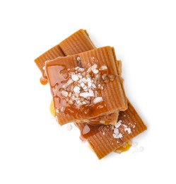 Photo of Yummy caramel candies and sea salt isolated on white, top view