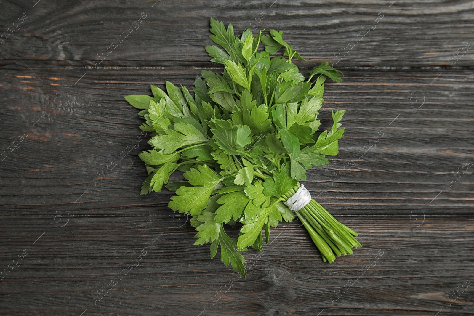 Photo of Bunch of fresh green parsley on wooden background, view from above