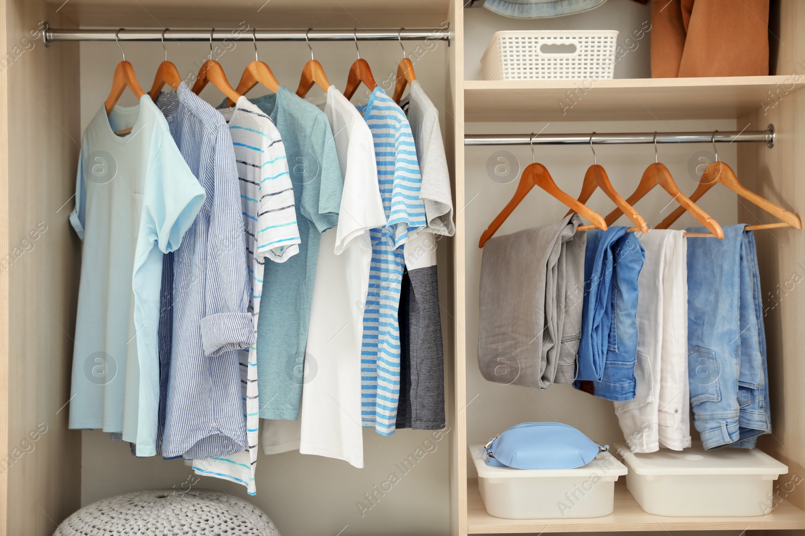 Photo of Stylish clothes on hangers in wardrobe closet