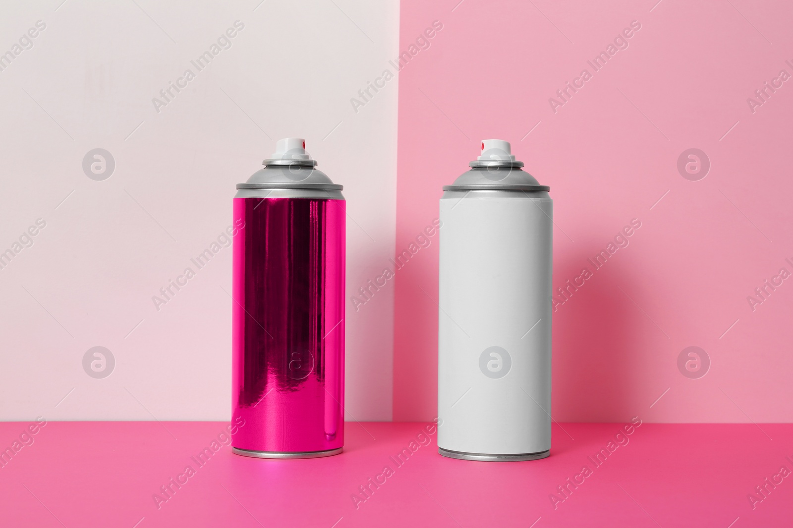 Photo of Cans of different spray paints on color background