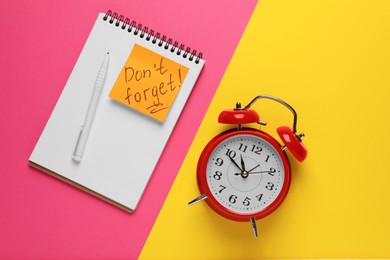 Photo of Alarm clock, pen, notebook and reminder note with phrase Don't forget on color background, flat lay