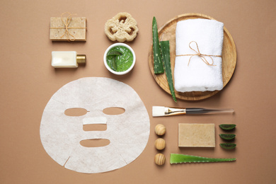 Flat lay composition with different cosmetic products and aloe on brown background