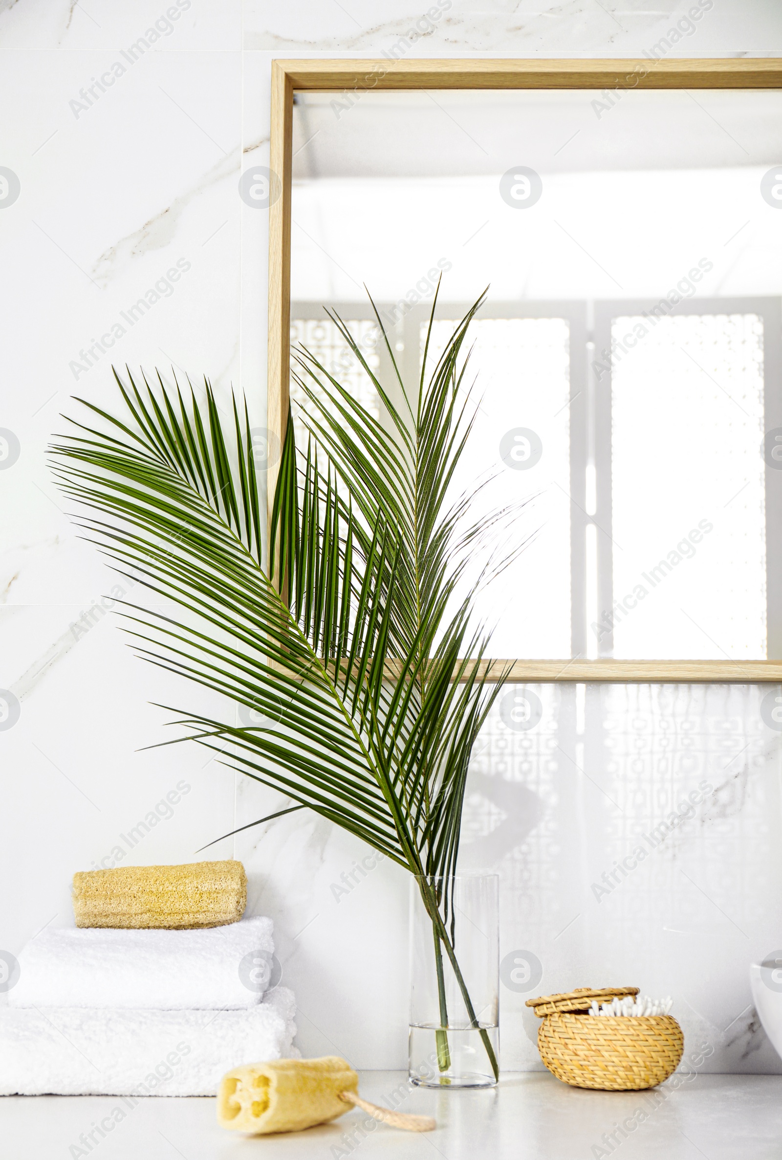 Photo of Tropical palm leaves in stylish bathroom interior