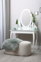 Photo of White dressing table with decor near beige wall in room