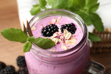 Photo of Delicious blackberry smoothie with oatmeal and berries in mason jar, closeup