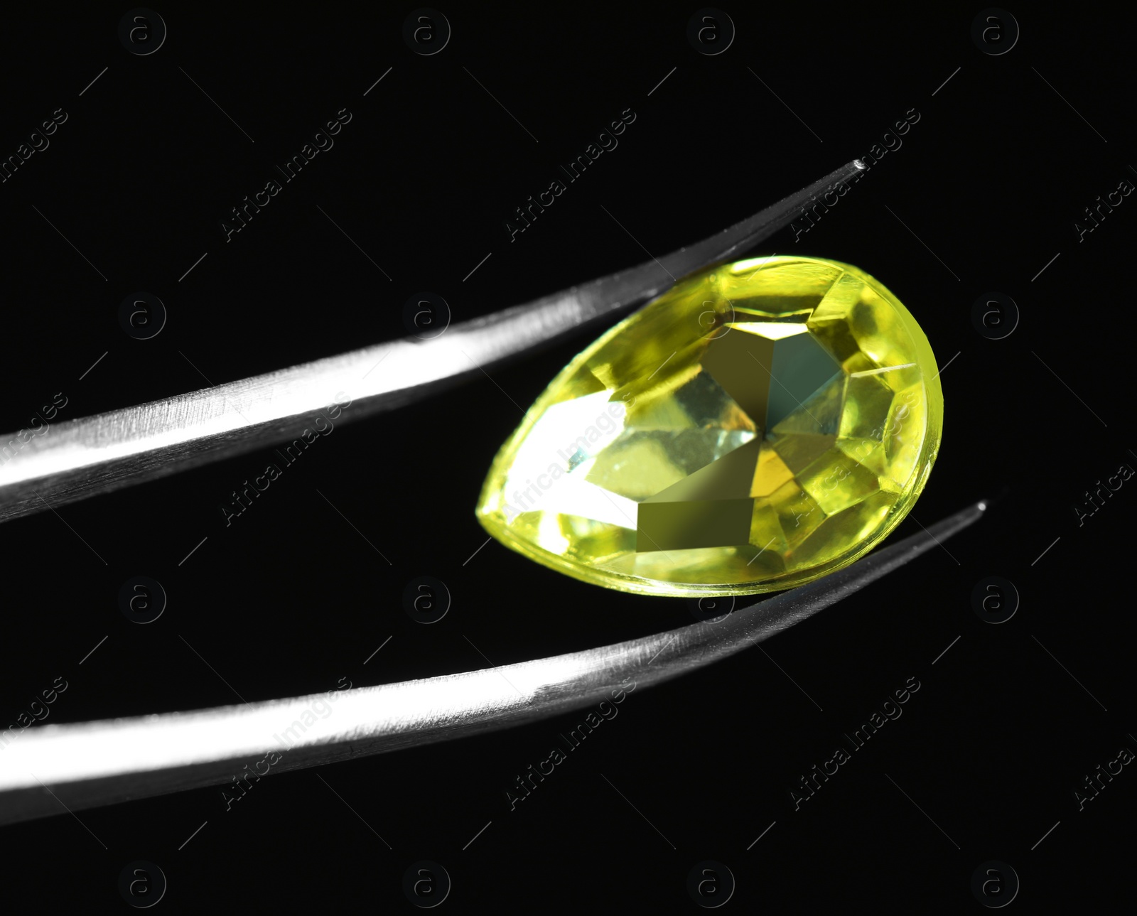 Photo of Tweezers with beautiful gemstone on black background