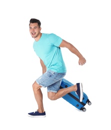 Young man running with suitcase on white background