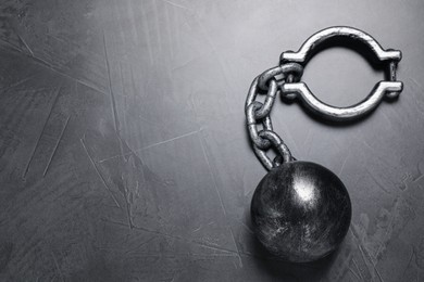 Photo of Prisoner ball with chain on grey table, top view. Space for text