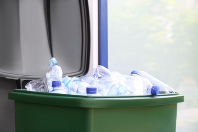 Many used plastic bottles in trash bin outdoors, closeup. Recycling problem