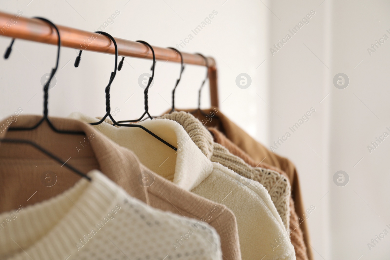 Photo of Rack with stylish women's clothes indoors, closeup. Modern interior design