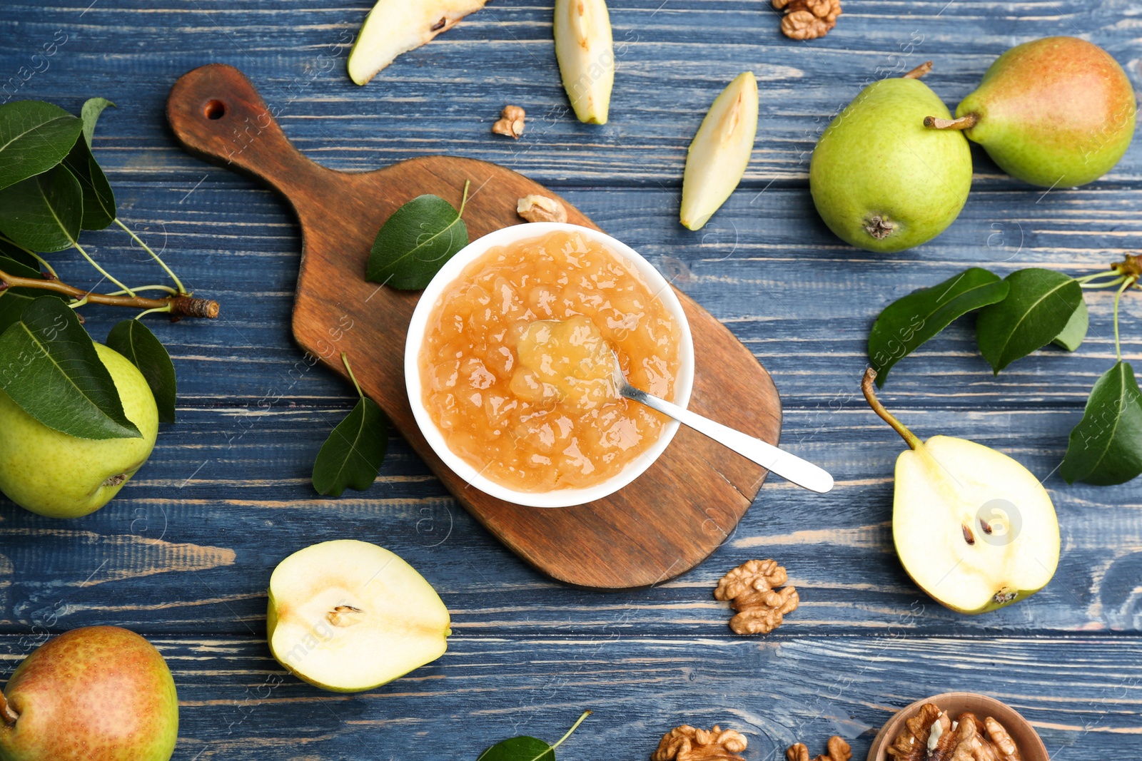 Photo of Tasty homemade pear jam and fresh fruits on blue wooden table, flat lay