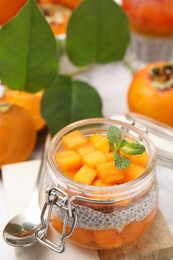 Photo of Delicious dessert with persimmon and chia seeds on table