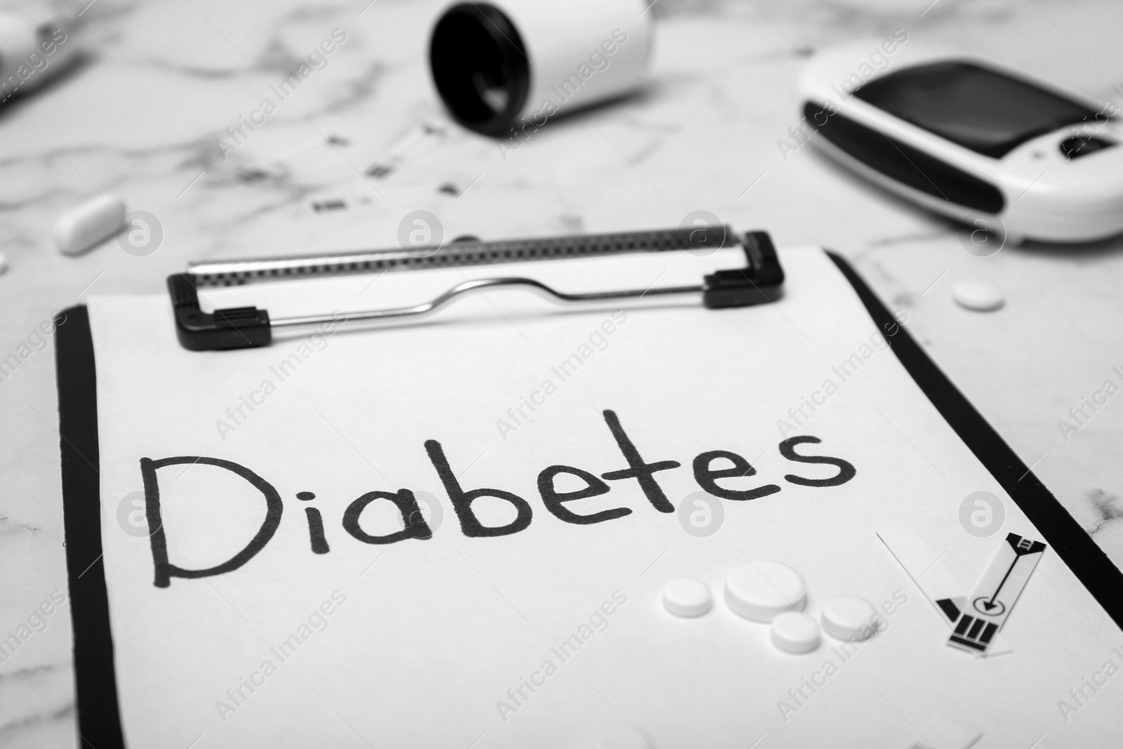 Photo of Composition with word "Diabetes", digital glucometer and medicine on marble background