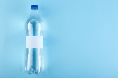 Photo of Bottle of water on color background, top view. Space for text