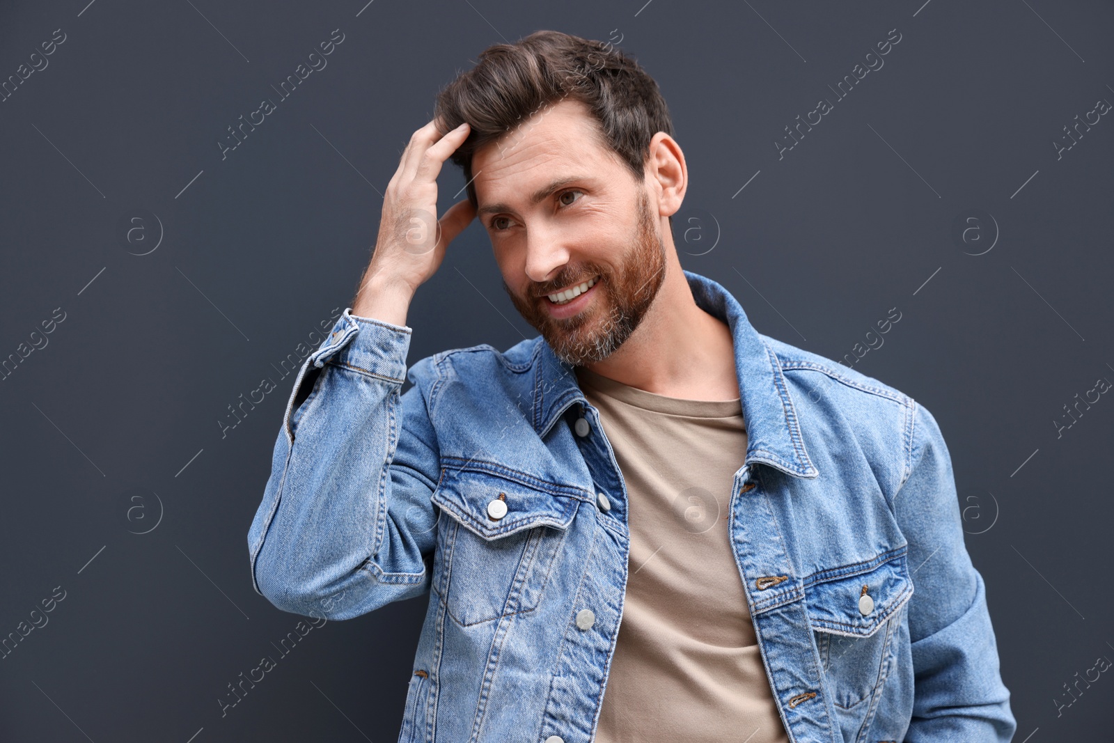Photo of Portrait of smiling handsome bearded man on grey background