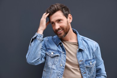 Portrait of smiling handsome bearded man on grey background