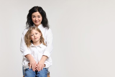 Photo of Beautiful mother with little daughter on white background. Space for text