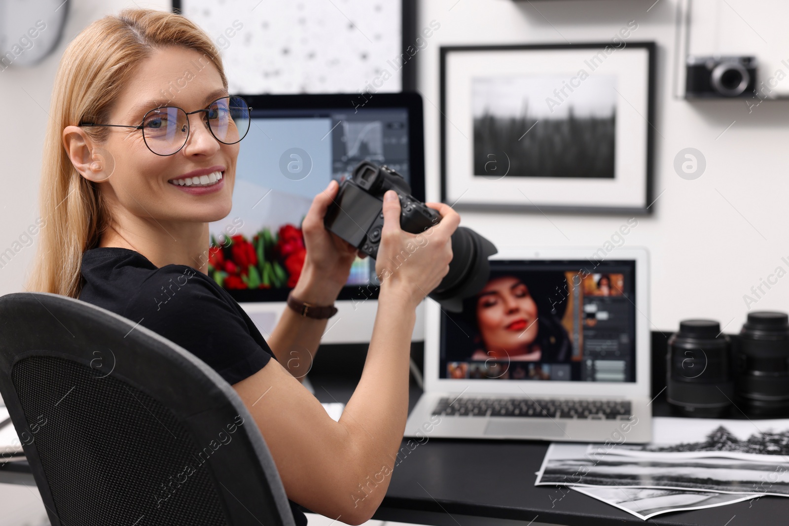 Photo of Professional photographer with digital camera at table in office