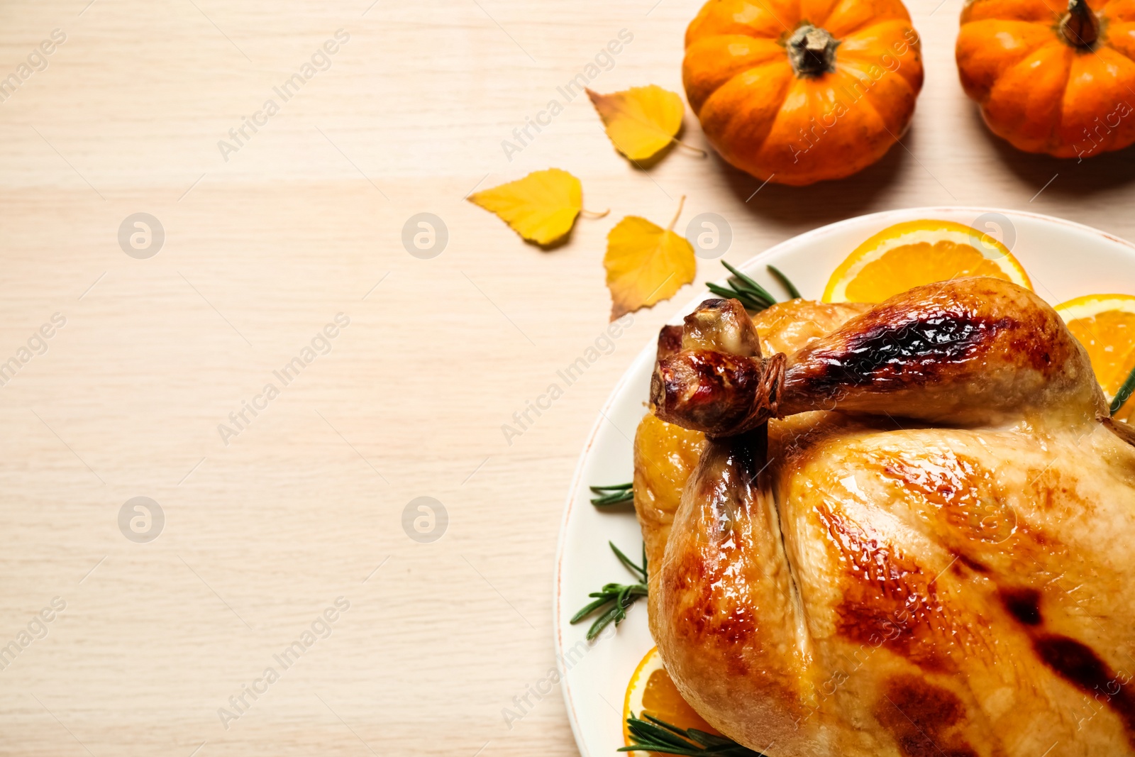 Photo of Traditional cooked turkey and autumn decor on wooden table, flat lay with space for text. Thanksgiving day celebration